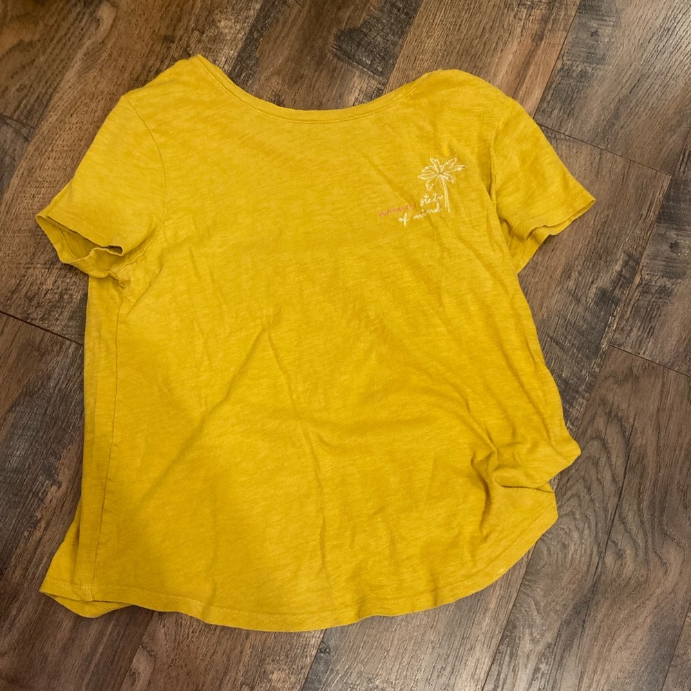 Women’s yellow shirt with embroidered words in the corner and a palm tree